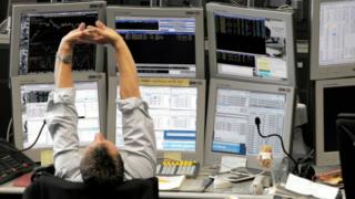 Banquero delante de las pantallas de trading