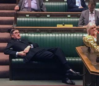 Jacob Rees-Mogg lying on chairs in Parliament