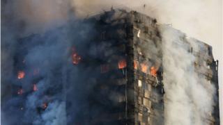 14 июня 2017 года на западе Лондона пожарные пытаются укрыться от пожара в башне Гренфелл