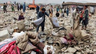 Afghan men search for their belongings after floods in Charikar