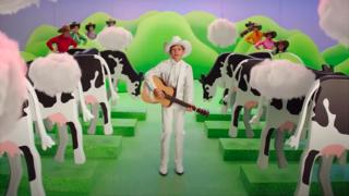 A boy wearing a cowboy hat sings about cow flatulence in a Burger King ad