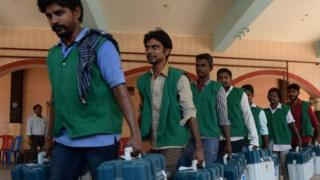 Индийские избиратели несут коробки с электронными машинами для голосования (EVM) в пункте распределения в Ченнае 17 апреля 2019 года, в преддверии второго этапа всеобщих выборов в Индии.