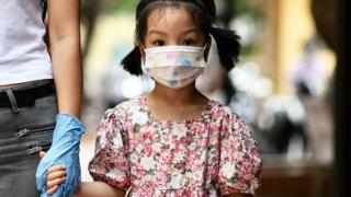 A young girl holds her mother's hand while waiting to be tested at a makeshift rapid testing centre in Hanoi, Vietnam - 1 August 2020