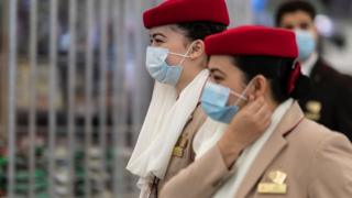 Crew members from Emirates airline are seen leaving Hong Kong international airport.