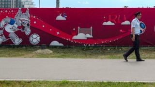 Полицейский на фоне рекламы футбольного турнира