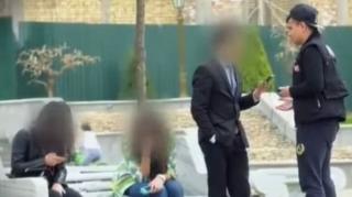 A MY5 presenter (right, backward baseball cap) confronts courting couples in a Tashkent park