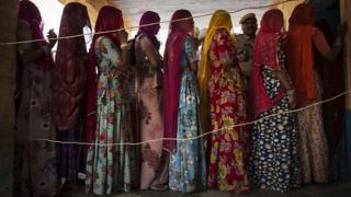 Индийские женщины ждут голосования на избирательном участке 17 апреля 2014 года в районе Джодхпур в пустынном штате Раджастхан, Индия. Индия находится в разгар девятиэтапных выборов, которые начались 7 апреля и завершатся 12 мая.
