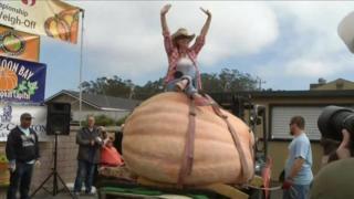 Woman sat on giant pumpkin