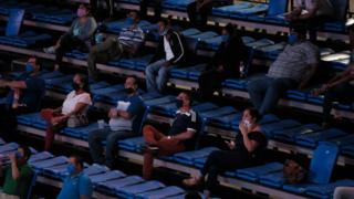 The audience sits apart from each other at a boxing match in Managua during the pandemic