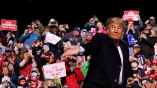 US President Donald Trump throws face masks to the crowd in Pennsylvania
