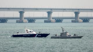 A seized Ukrainian ship is towed by a Russian Coast Guard vessel out of the port in Kerch, near the bridge connecting the Russian mainland with the Crimean Peninsula, 17 November 2019
