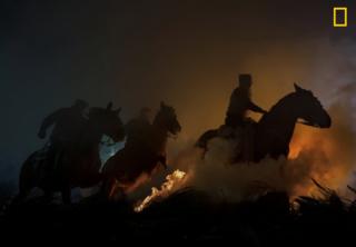 Horses leap over flames