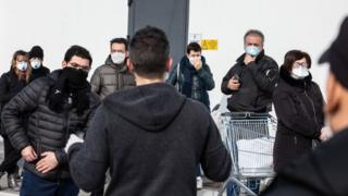 اهالی شهرک کاسالپوسترلنیو در شمال غربی میلان در صف سوپرمارکت