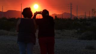 Eine Mutter und eine Tochter machen Fotos vom Feuer