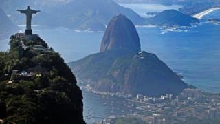Christ the Redeemer statue atop Corcovado the Sugar Loaf Hill (behind) and the Guanabara Bay in Rio de Janeiro, Brazil on May 10, 2013.