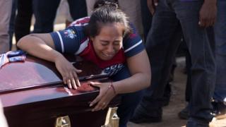 Mujer llorando sobre un féretro