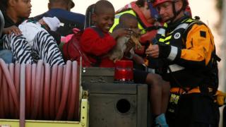 A member of FEMA hands a child his dog on a truck as people are evacuated from a flood area as a result of Hurricane Mathew in Lumberton, North Carolina, U.S. October 10, 2016