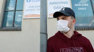 A man in a mask outside a job center in Newcastle-under-Lyme, Staffordshire.