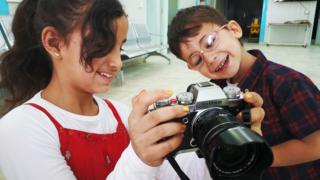 Refugee children with camera