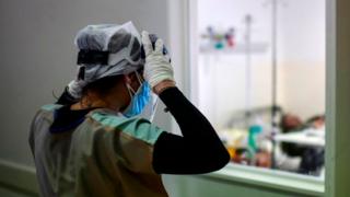 Doctor Analia Mondo looks at a patient infected with the new coronavirus at the Doctor Alberto Antranik Eurnekian Public Hospital in Ezeiza, in the outskirts of Buenos Aires