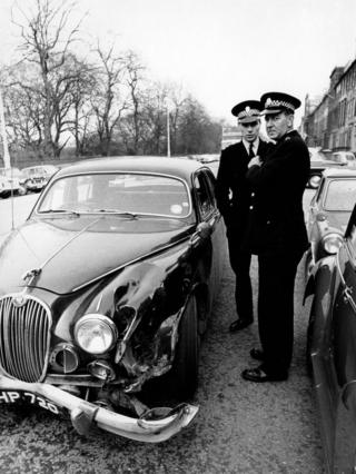 Two policemen next to a car accident, 1966.