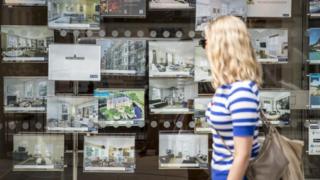 Woman looking in estate agents' window