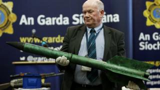 Detective Sergeant Tom Carey holds a rocket, one example of the weapons seized over the last two years by detectives combating dissident republic violence in the Republic of Ireland