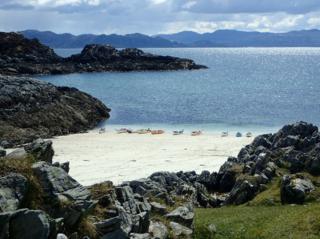 Kayaks lined up on Arisaig beach.