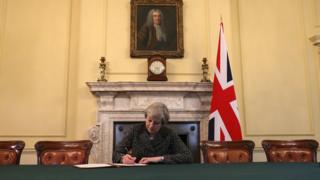 İngiltere Başbakanı Theresa May, Brexit sürecini başlatacak olan mektubu imzalarken.