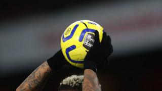 Joueur avec une balle de match contenant un message antiraciste