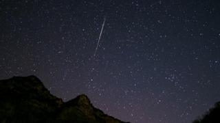 Starry night sky with a shooting star of the Geminid meteor shower