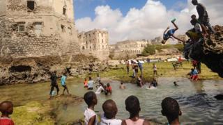 Watoto wa kisomali wanaogelea na kucheza mbele ya magofu ya nyumba ya zamani katika pwani ya Hamarweyne, jijini Mogadishu Ijumaa.