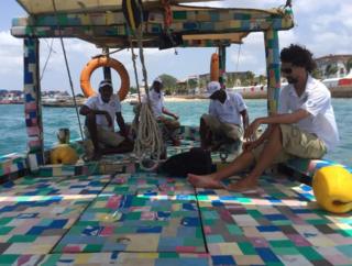 People sit on board the Flip-flop Dhow