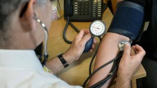 GP taking someone's blood pressure