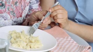 Carer helping patient eat