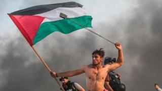 Warga Palestina melempari batu dan membakar ban sebagai tanggapan terhadap pasukan Israel selama demonstrasi maritim di Kota Gaza pada 22 Oktober 2018
