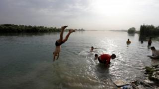 Ein irakischer Junge taucht in Mosul in den Tigris ein