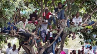 Сторонники слушают бывшего премьер-министра Танзании и кандидата в президенты Эдварда Лоуассу, когда он проводит предвыборную встречу 1 октября в Дар-эс-Саламе. Граждане Танзании выберут нового президента 25 октября