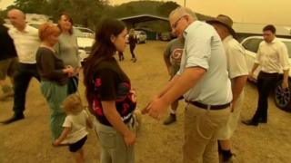 Scott Morrison mova a mão de uma mulher em Cobargo, New South Wales