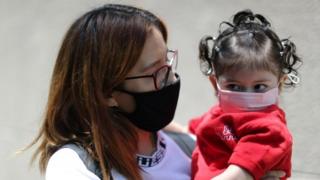 A woman holds her daughter near a hospital in Los Angeles, California. Photo: July 2020