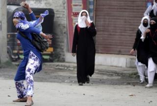 Студентка из Кашмира бросает камень в полицию во время столкновений в Сринагаре, летней столице индийского Кашмира, 24 апреля 2016 года