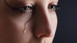 Una toma muy cerrada del rostro de una mujer que llora