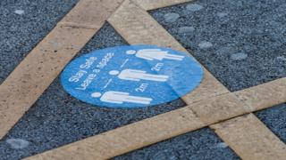 'Stand two metres apart' sign on station floor