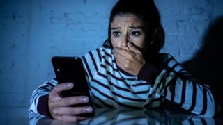 Una mujer viendo una pantalla