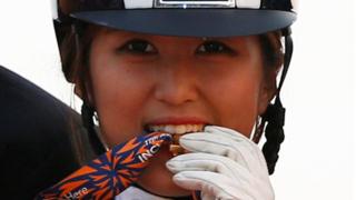 2014年9月20日,郑尤拉在仁川亚运会赢得马术盛装舞步团体金牌,她将金牌咬在嘴里