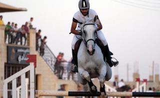 A rider on his horse jumps over a barrier during the Knights of Libya Festival in Benghazi, Libya - Tuesday 7 August 2018