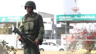 Militar de guardia frente a una gasolinera.