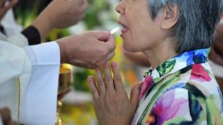 Umuntu ari gusangira mu misa muri Taiwan itariki 10/08/2018
