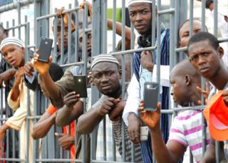 Liberians uses their mobile phones to take a photo of Sheikh Ahmed Mohammed Awal during his Dawah Tour at the Antoinette Tubman Soccer Stadium in Monrovia, Liberia on 9 July 2017