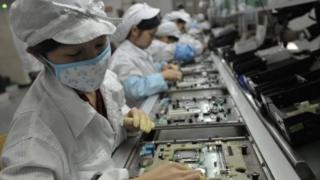 手机的生产线上,成千上万的工人并排而坐